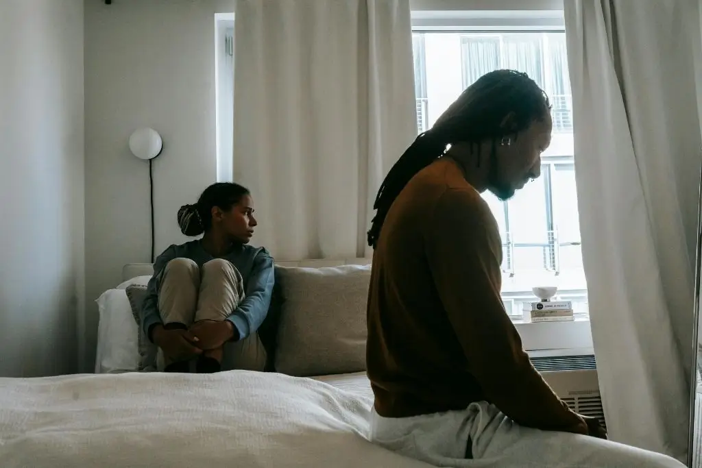 A couple experiencing emotional distance in their bedroom.